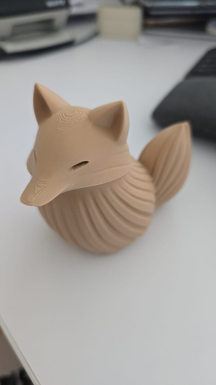 Kleine sitzende Fuchsfigur mit buschigem Schwanz