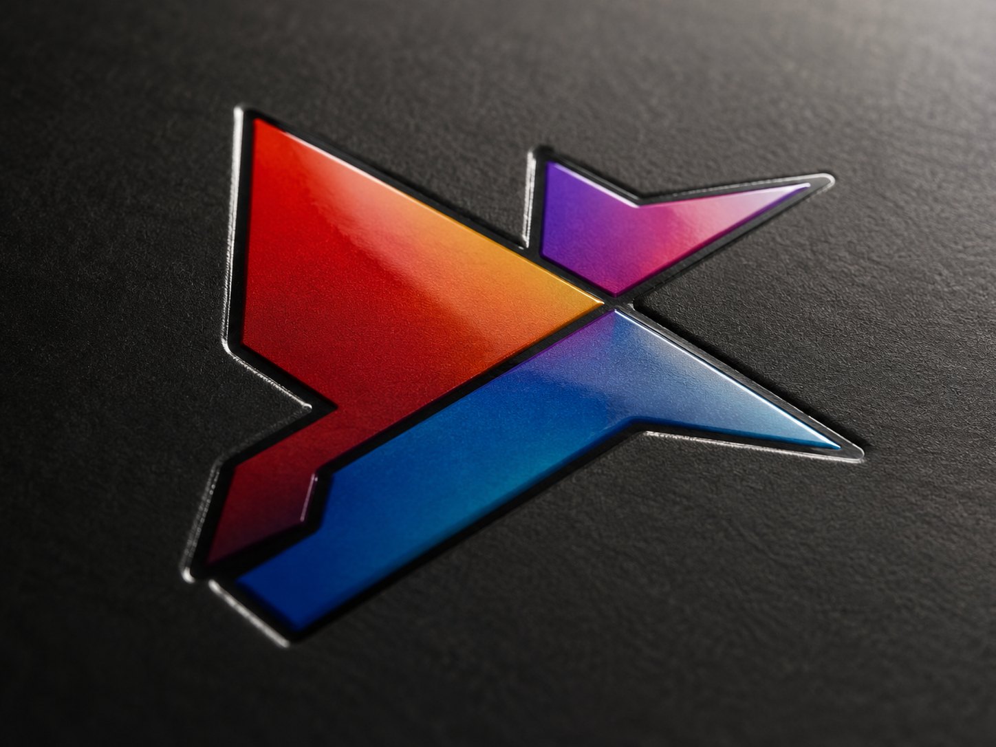 Vollfarbig bedrucktes Logo mit Farbverlauf von Rot über Violett zu Blau, direkt auf eine schwarze Lederoberfläche gedruckt, mit glänzender, leicht erhabener Oberfläche